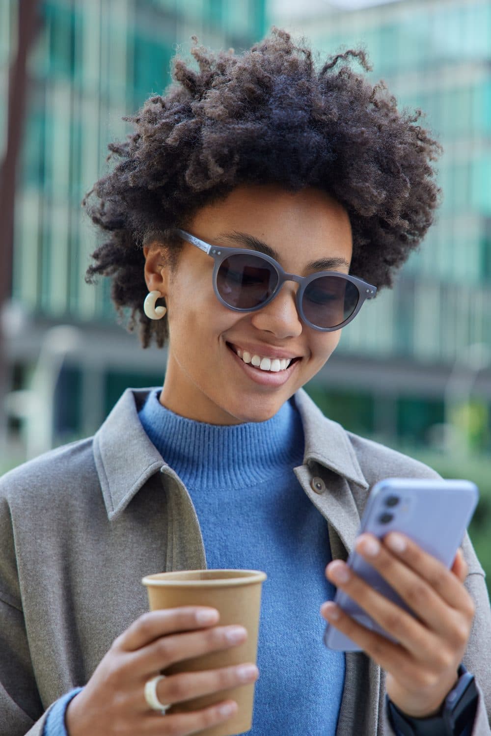 Smiling traveler in the city using her phone, online with a StrongeSIM eSIM